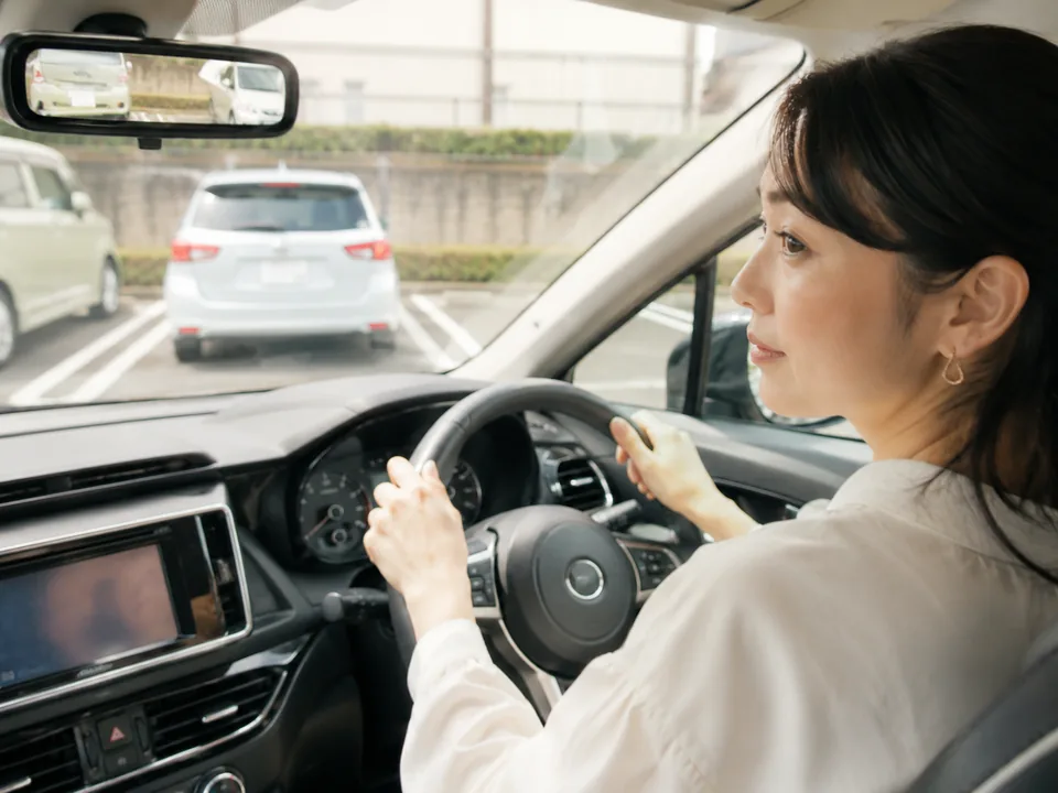 駐車に不安を感じながら運転する女性